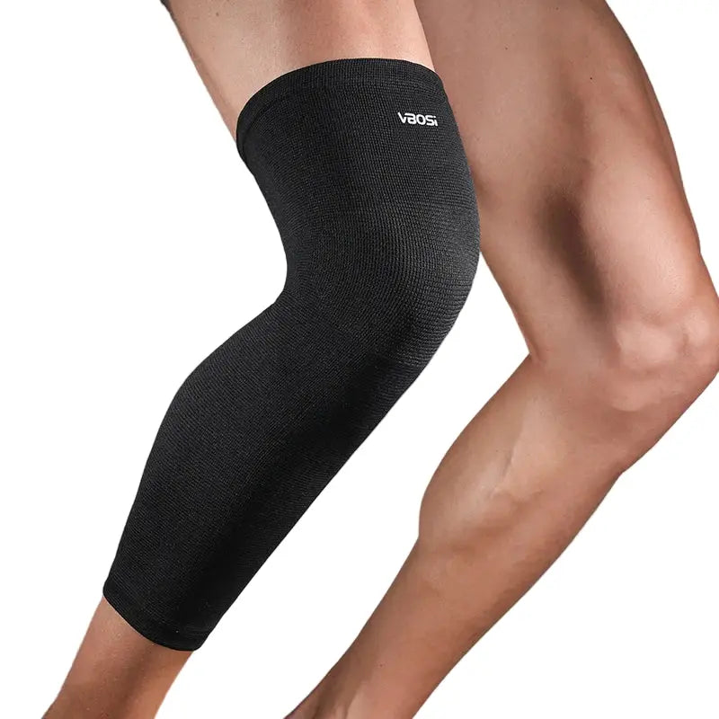Manchon de compression noir porté sur la jambe et le genou pour maintien musculaire et soutien articulaire