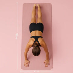 Vue du dessus d’une femme en position gainage sur tapis de yoga rose épais avec dimensions 183 x 61 cm